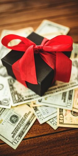 A picture of a boxed present on top of cash symbolizing the gift of life insurance.