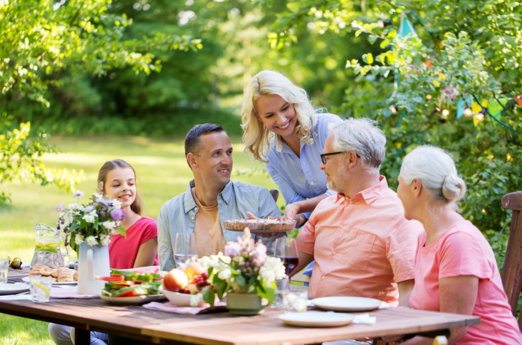 Picture of three generation family and Children at a picnic table. Children, parents or grandchildren are good life insurance beneficiary options.