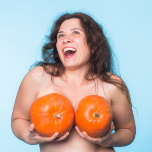 A smiling woman with a pumpkin breast
