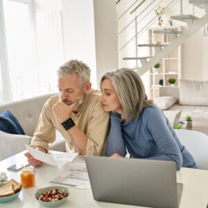 How to Determine if Your Parent Needs Life Insurance: A picture of senior parents checking on their debts. Think about what type of lifestyle your parents would want to maintain and if life insurance is necessary to cover any expenses related to that.